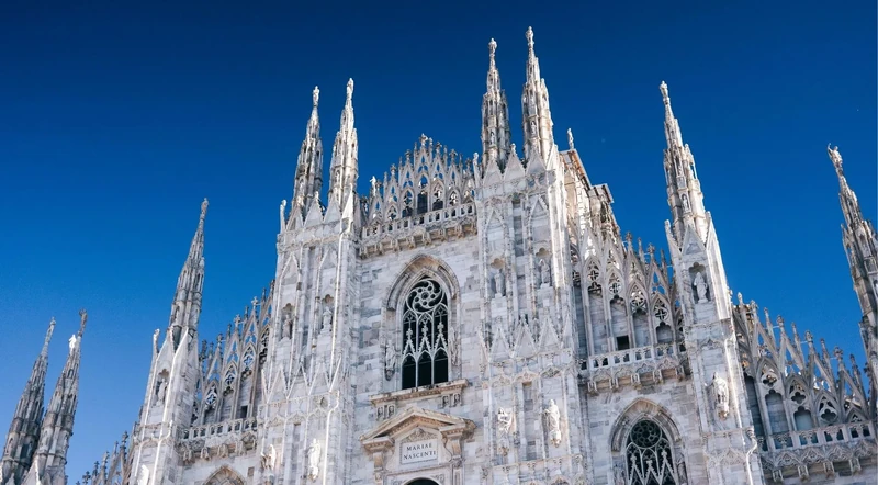 Close-up of Gothic spires and pale marble on the Milan Cathedral rooftop