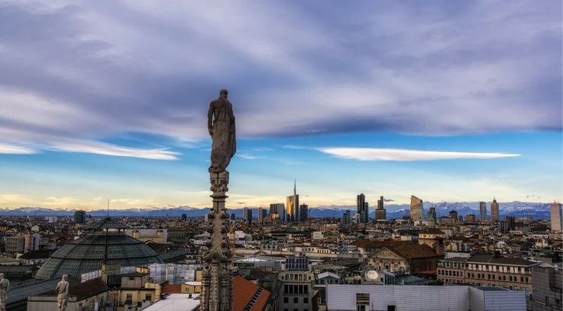 View from the Milan Duomo rooftop toward the city skyline and the Alps beyond