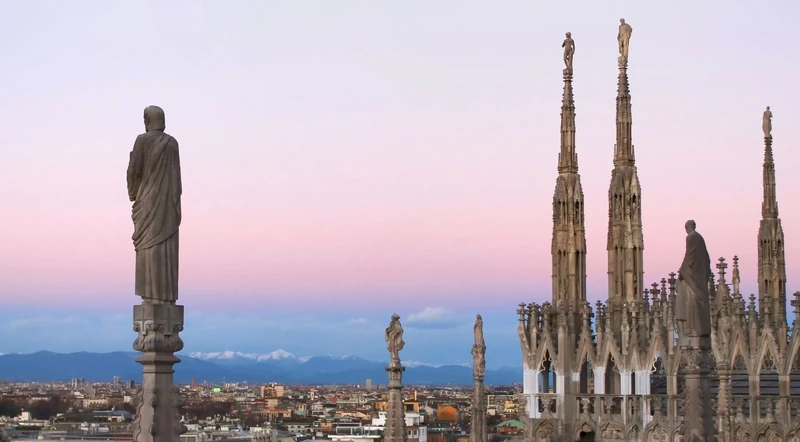Sunset light across statues and marble terraces on the Milan Cathedral roof